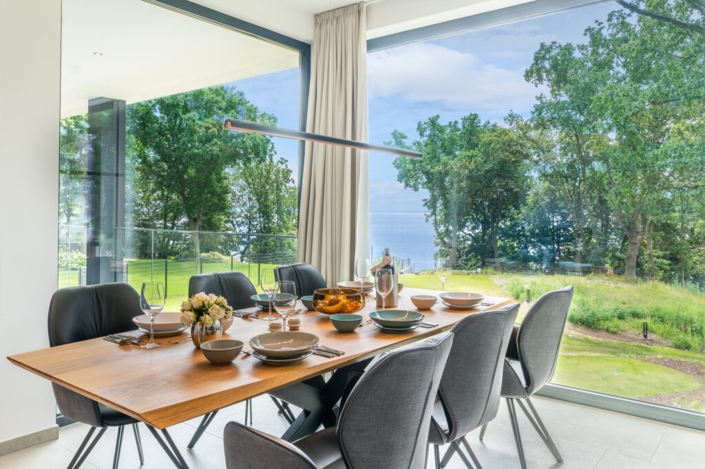 Essbereich des Apartments „Freya“ in den Luxus-Ferienwohnungen DECK9 am Haff auf Usedom mit Panoramafenstern.