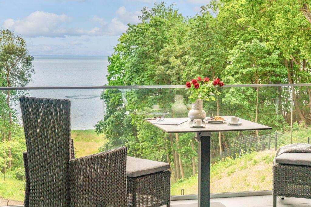 Balkon der Luxus-Ferienwohnungen DECK9 mit Sitzplatz und Blick ins Grüne Richtung Haff auf Usedom.