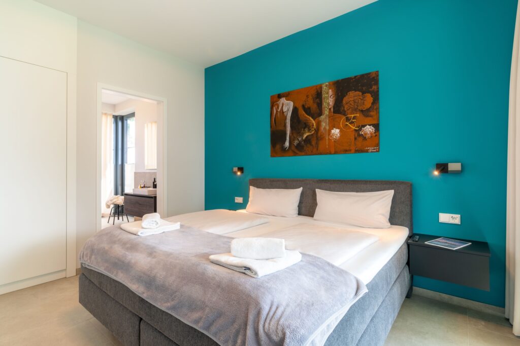 Helles Schlafzimmer mit Doppelbett und modernem Design im Apartment „Smilla“ der Luxus-Ferienwohnungen DECK9 am Haff auf Usedom.