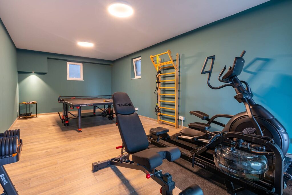 Moderner Fitnessraum mit Trainingsgeräten und Tischtennis im Gemeinschaftsbereich der Ferienwohnungen DECK9 auf Usedom